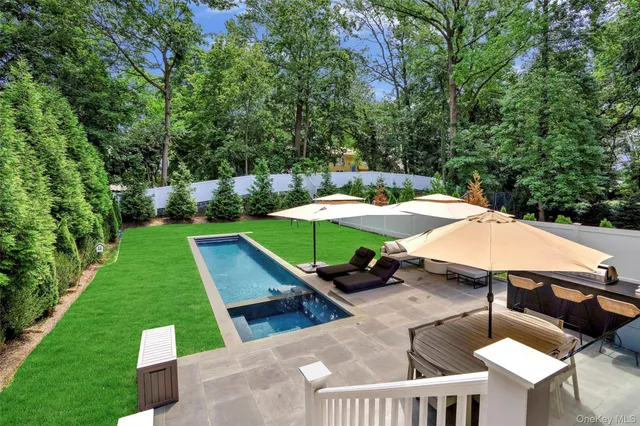 a view of a patio with table and chairs potted plants with wooden floor and fence