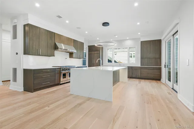 a large kitchen with stainless steel appliances granite countertop a large counter top and a stove top oven