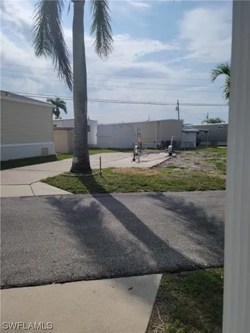 a view of a yard and car parked in front of it