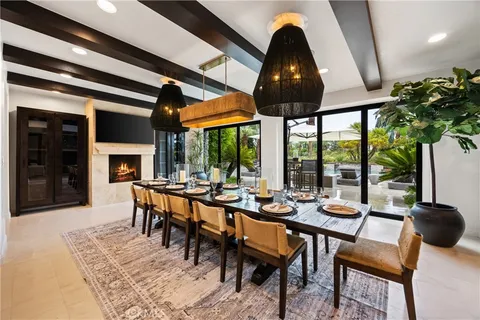 a dining room with furniture a fireplace and large windows