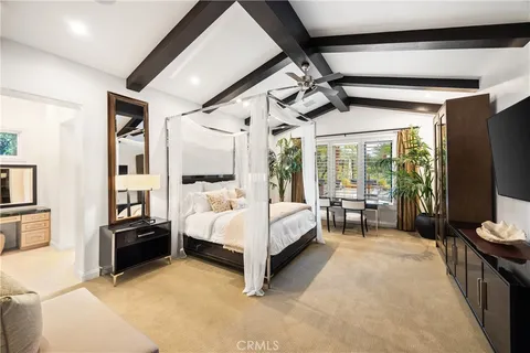 a bedroom with a large bed and a flat screen tv