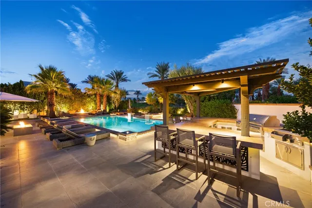a view of a house with swimming pool and sitting area