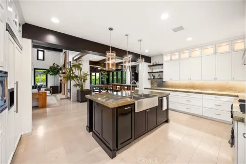 a kitchen with stainless steel appliances kitchen island granite countertop a stove and a sink