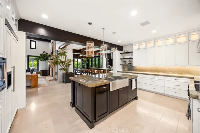 a kitchen with stainless steel appliances kitchen island granite countertop a stove and a sink