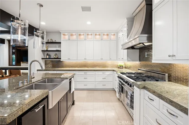 a kitchen with stainless steel appliances granite countertop a sink stove and cabinets