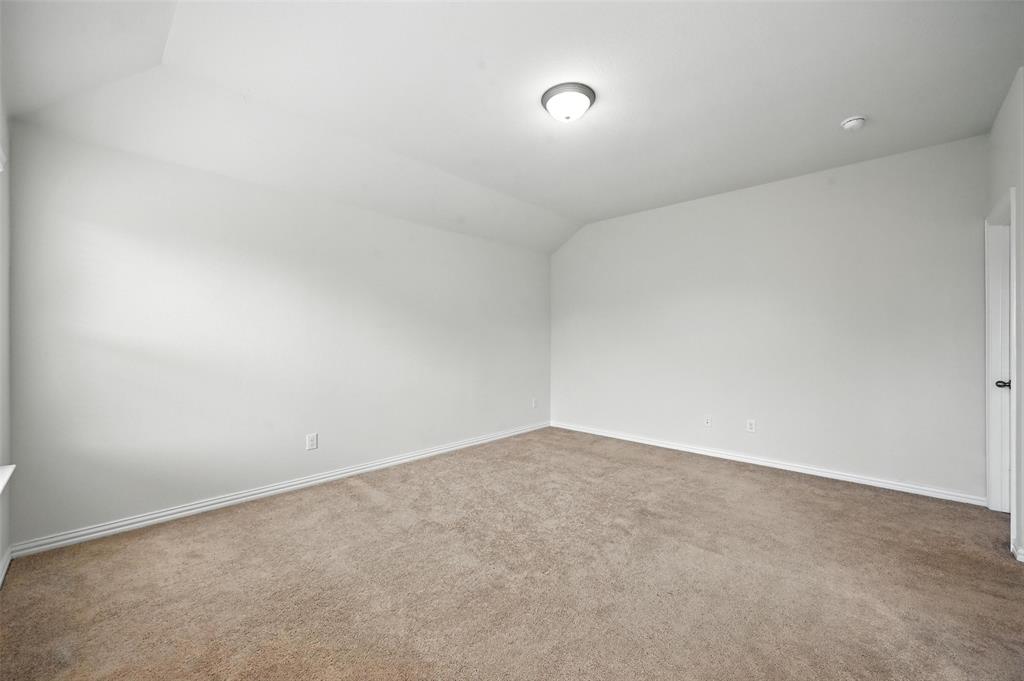 5 Pheasant Run Sanger, TX 76266 - Photo 21 of 27 Spare room featuring vaulted ceiling and light carpet