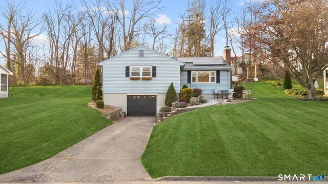 a front view of a house with a yard and trees