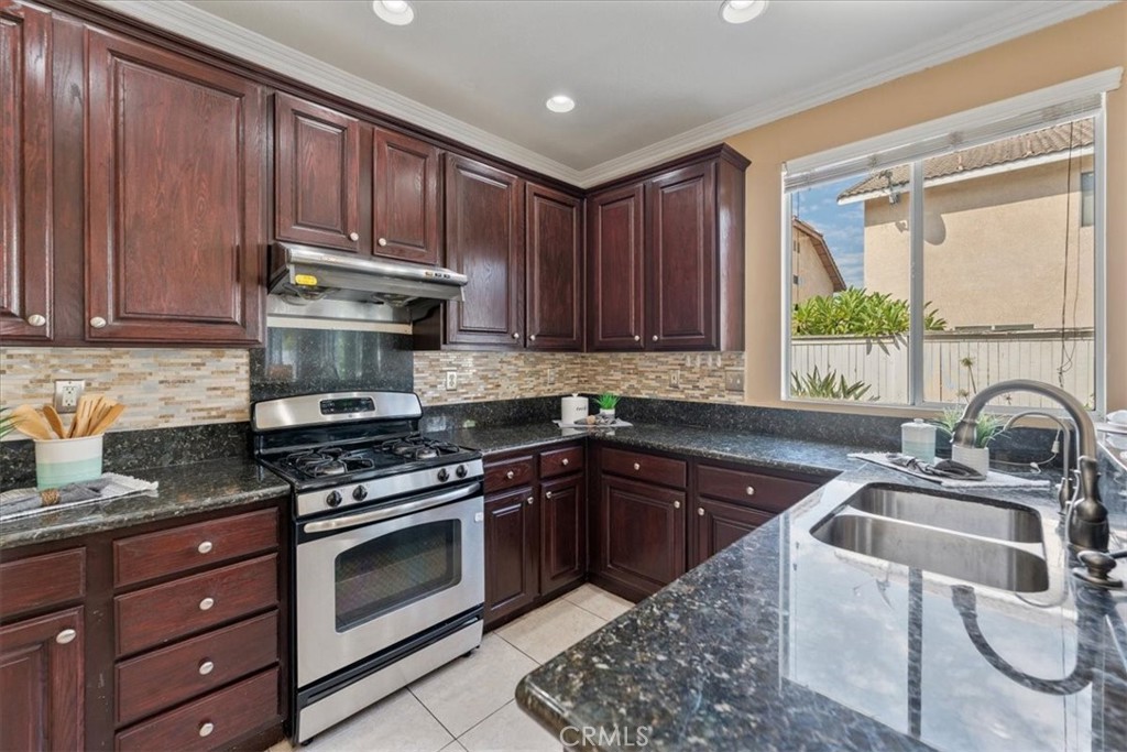 10562 Mustang Circle Montclair, CA 91763 - Photo 5 of 19 a kitchen with granite countertop a sink stainless steel appliances and cabinets