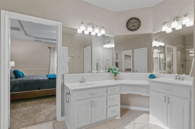 a spacious bathroom with a double vanity sink mirror and chandelier