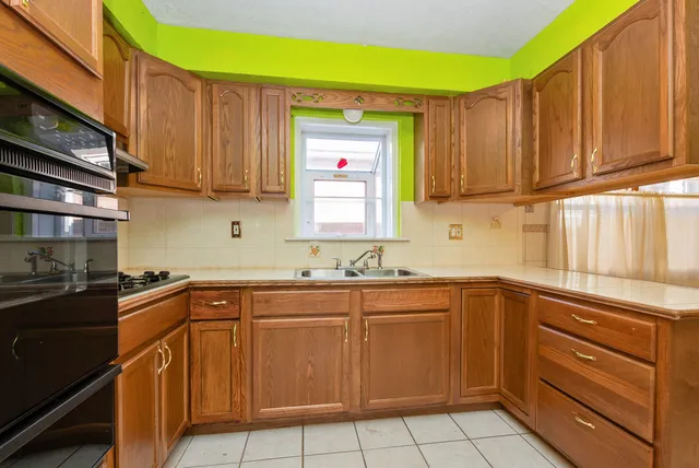 a kitchen with a sink dishwasher stove and cabinets