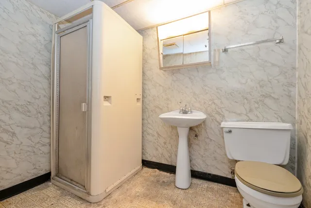 a bathroom with a sink a toilet and shower