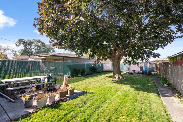 a view of a patio with table and chairs under an umbrella