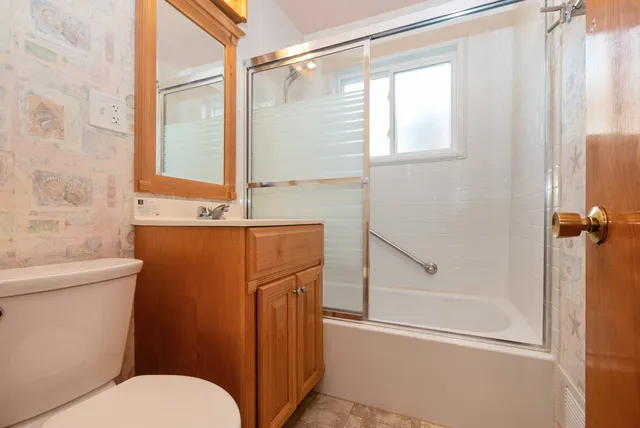 a bathroom with a shower a toilet and a sink