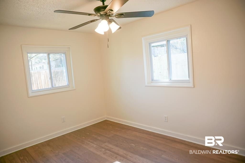4159 Rebecca Road Mobile, AL 36609 - Photo 17 of 19 Unfurnished room with a healthy amount of sunlight, dark wood-style floors, and baseboards