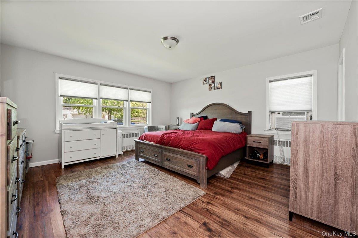 534 Allen Road Woodmere, NY 11598 - Photo 15 of 35 a spacious bedroom with a bed and wooden floor