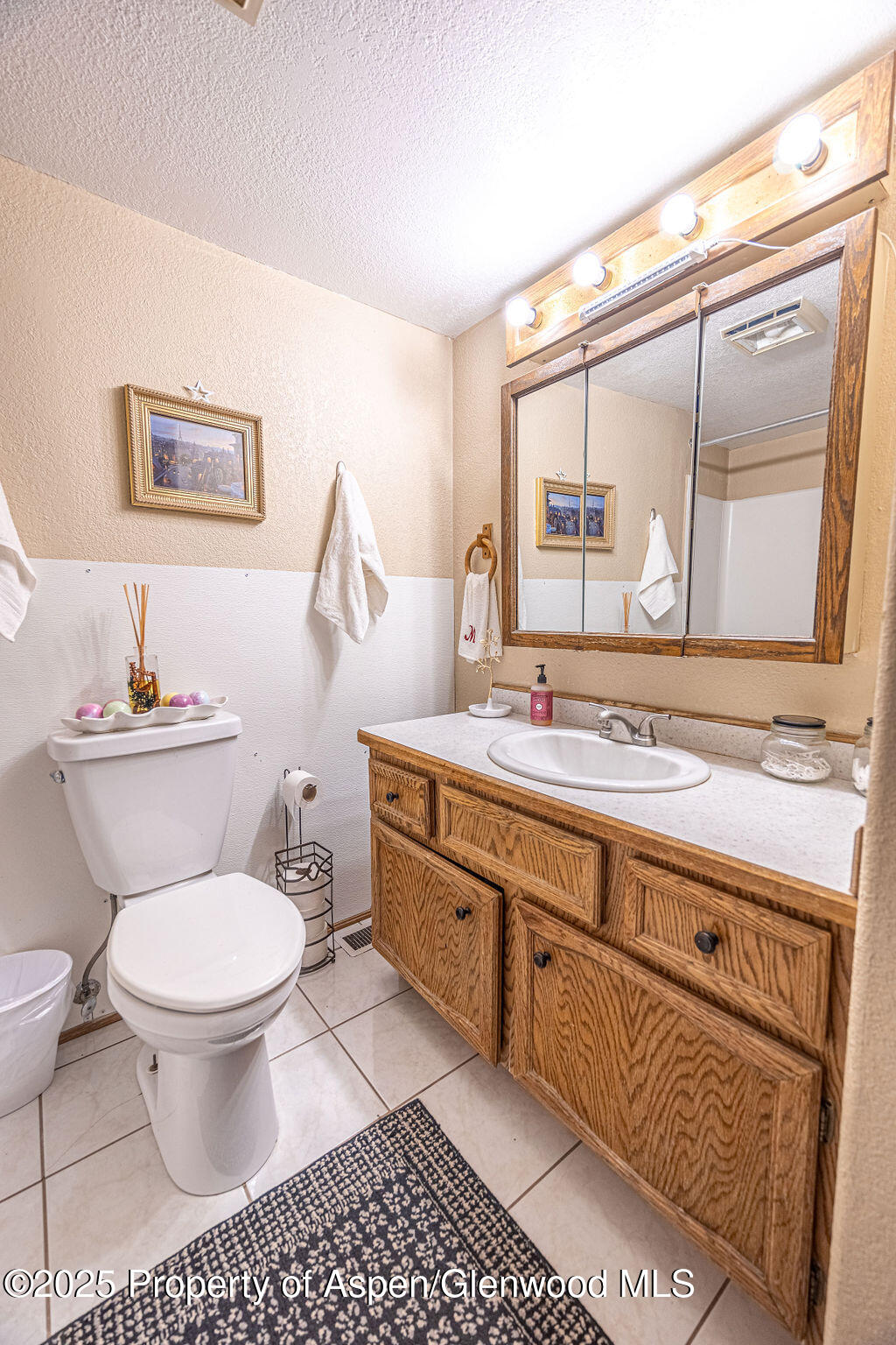 298 Middle Street Rangely, CO 81648 - Photo 22 of 75 a bathroom with a granite countertop toilet a sink and a mirror