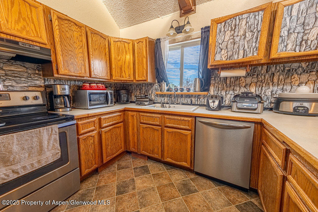 298 Middle Street Rangely, CO 81648 - Photo 6 of 75 a kitchen with stainless steel appliances granite countertop a sink stove and cabinets