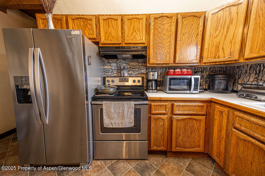 298 Middle Street Rangely, CO 81648 - Photo 7 of 75 a kitchen with stainless steel appliances granite countertop a refrigerator and a stove top oven