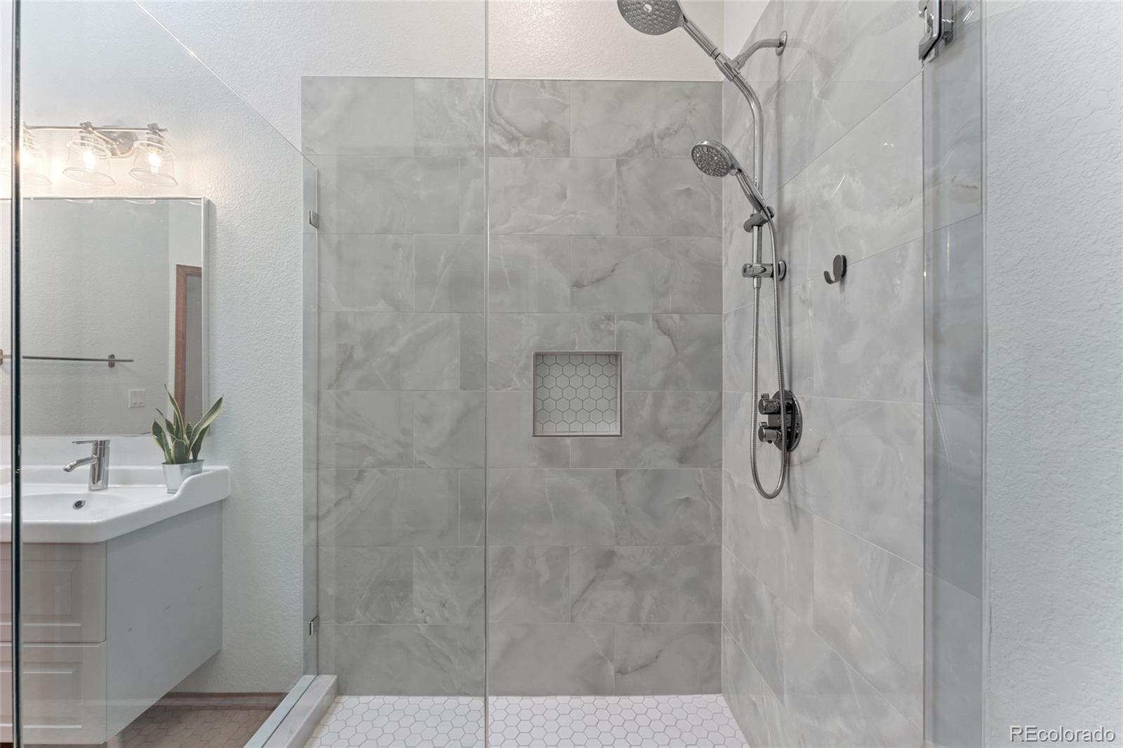 92 Ward Court Lakewood, CO 80228 - Photo 23 of 37 a bathroom with a shower and a sink