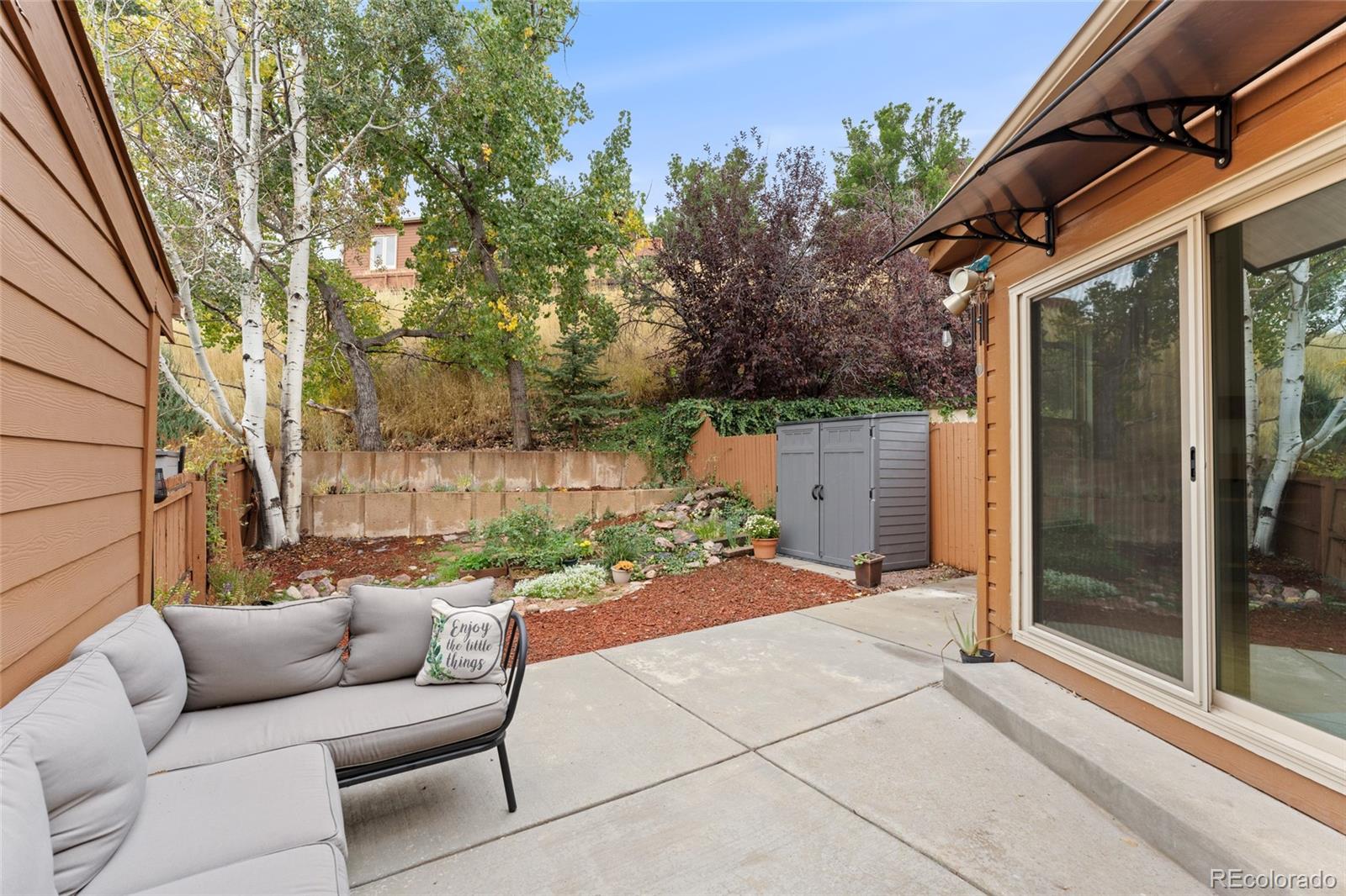 92 Ward Court Lakewood, CO 80228 - Photo 27 of 37 a backyard of a house with fountain and outdoor seating