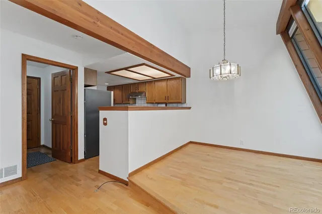 a view of a livingroom with wooden floor and stairs