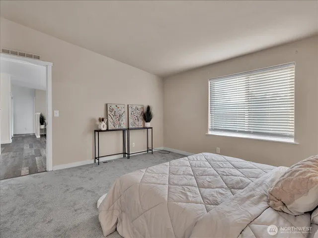 a bedroom with a bed and a painting on the wall