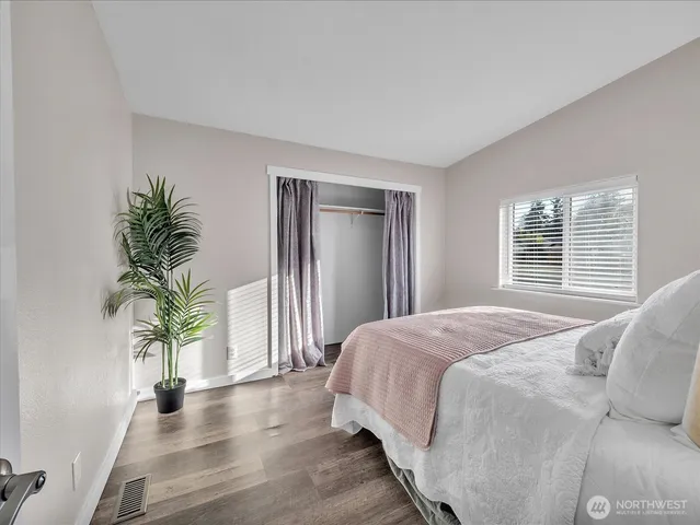 a bedroom with a large bed and a potted plant