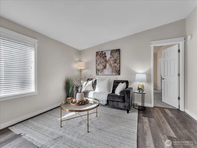 a living room with furniture and a wooden floor