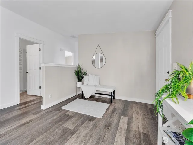 a living room with wooden floor furniture and potted plant