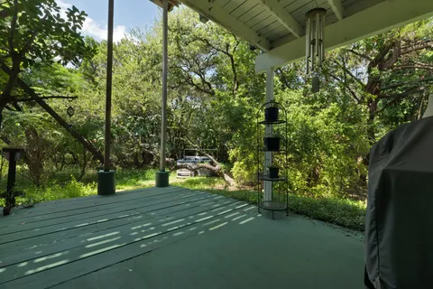 a balcony with wooden floor table and chairs