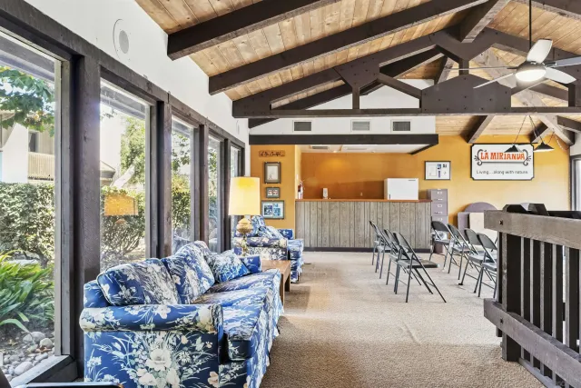 a view of a dining room with furniture large windows and backyard