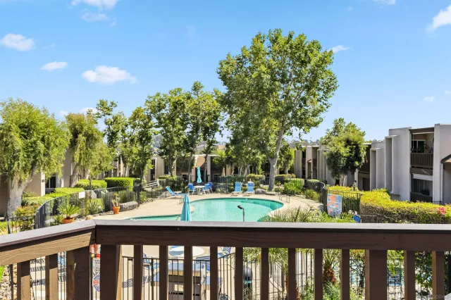a white bed sitting in a bedroom next to a window with kitchen countertop