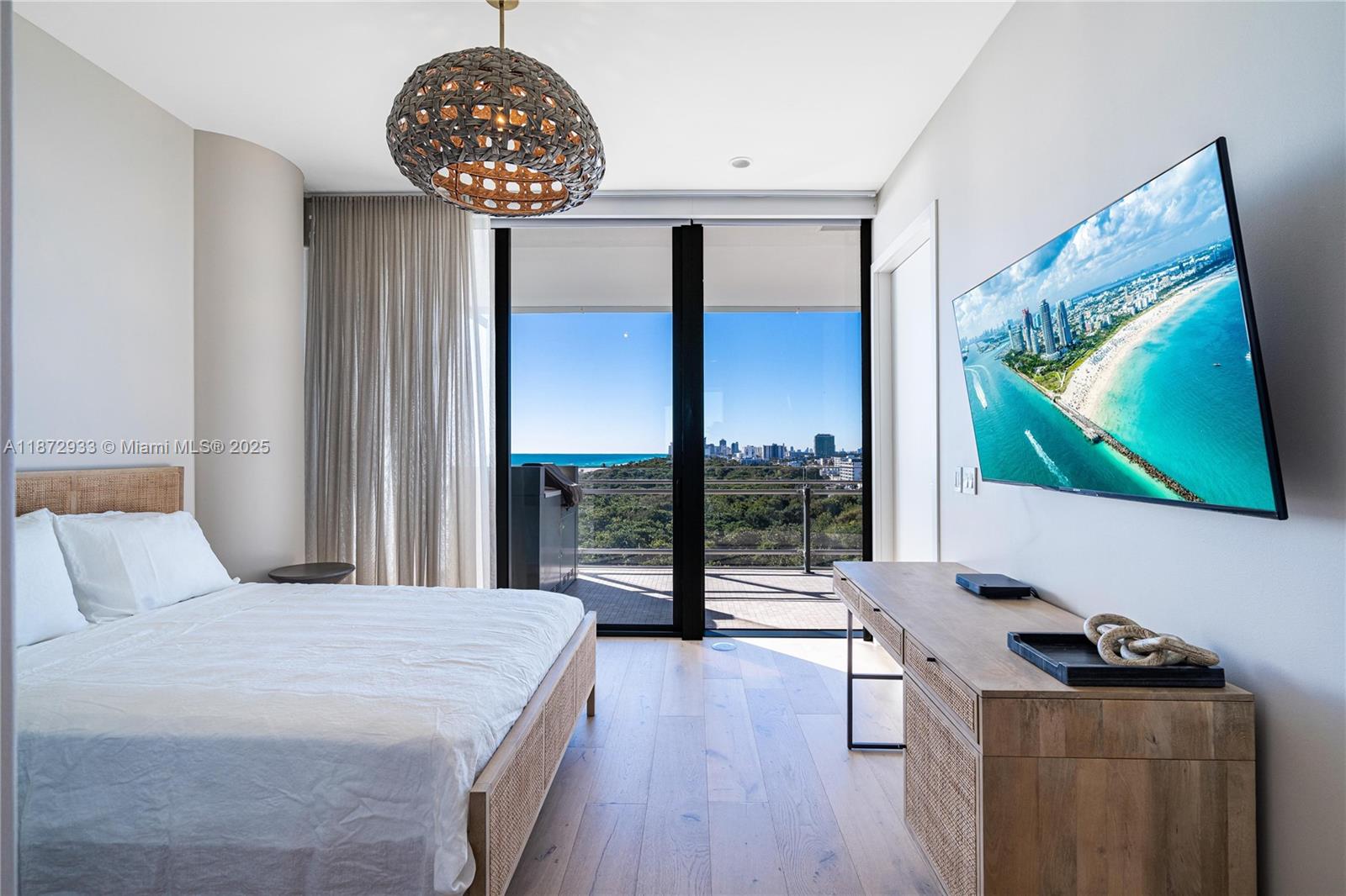 8701 Collins Avenue, Unit 804 Miami Beach, FL 33154 - Photo 21 of 25 a bedroom with a bed and a flat screen tv