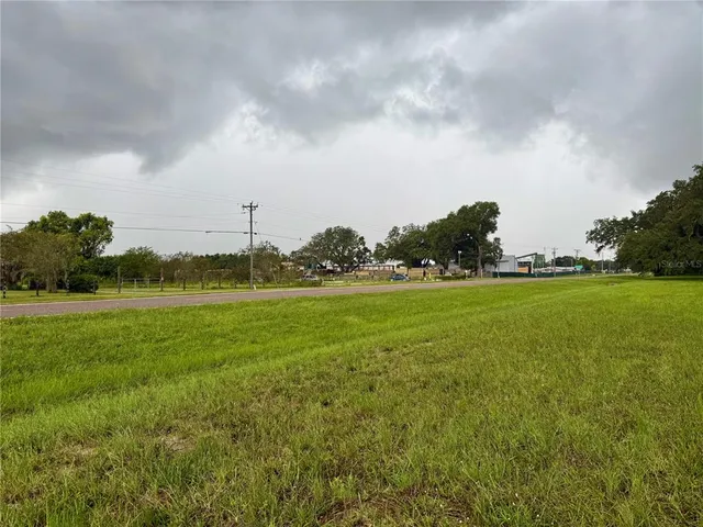 a view of a green field with wooden fence