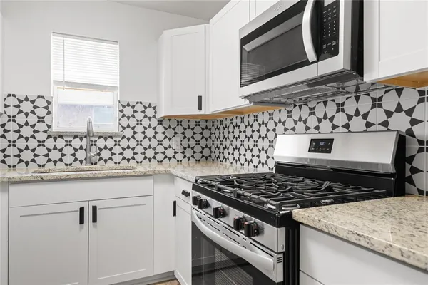 a kitchen with granite countertop a stove and a sink