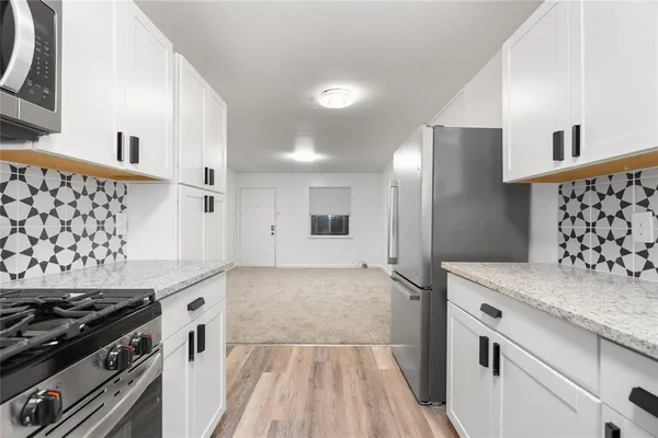 a kitchen with granite countertop a refrigerator and a sink
