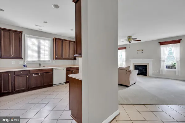 a large kitchen with a stove a sink dishwasher and a refrigerator with wooden floor
