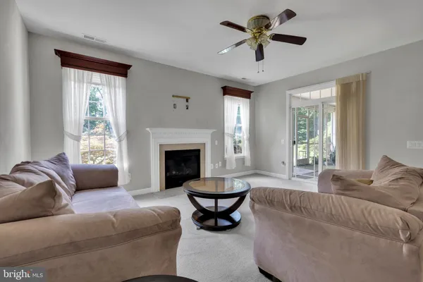 a living room with furniture a fireplace and a large window