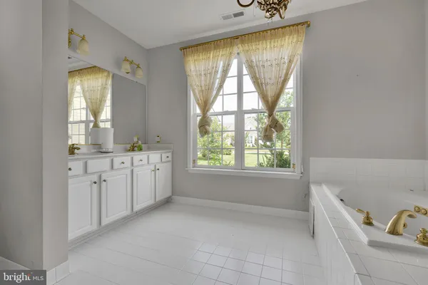 a bathroom with a tub sink and mirror