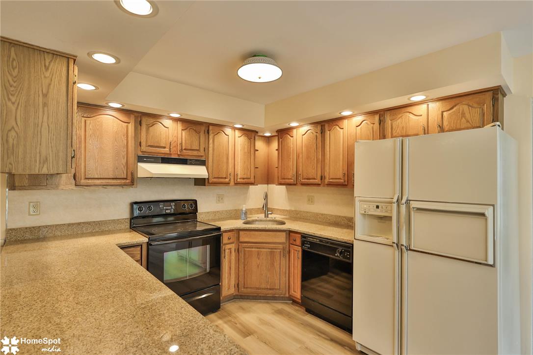 4059 Wedgewood Road Allentown, PA 18104 - Photo 15 of 72 An inviting kitchen features granite counters, natural wood cabinetry, and a full suite of appliances.