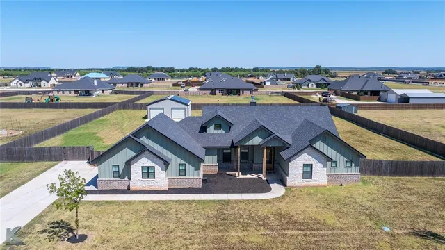 a view of a house with a big yard and large trees