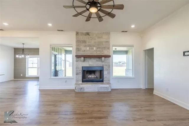 a view of an empty room with a fireplace and a window