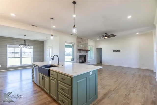 a kitchen with kitchen island a sink stainless steel appliances and a chandelier