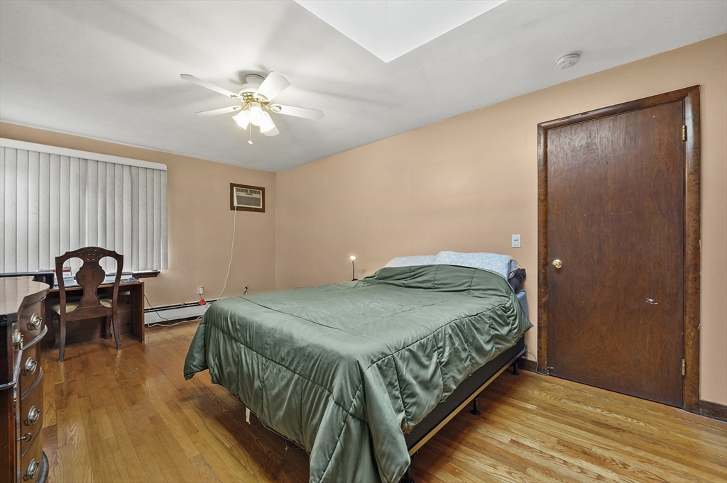 577 Grove Street Worcester, MA 01605 - Photo 19 of 39 a bedroom with a bed and a chandelier
