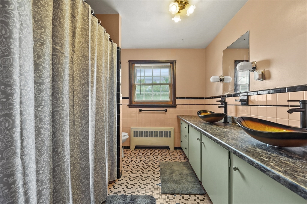 577 Grove Street Worcester, MA 01605 - Photo 20 of 39 a bathroom with a granite countertop sink and a mirror