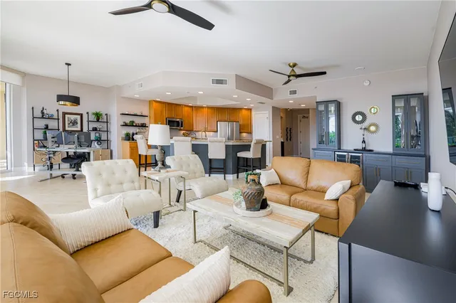 a living room with furniture kitchen view and a large window
