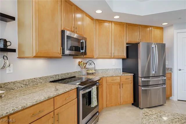 a kitchen with stainless steel appliances granite countertop a refrigerator stove and microwave