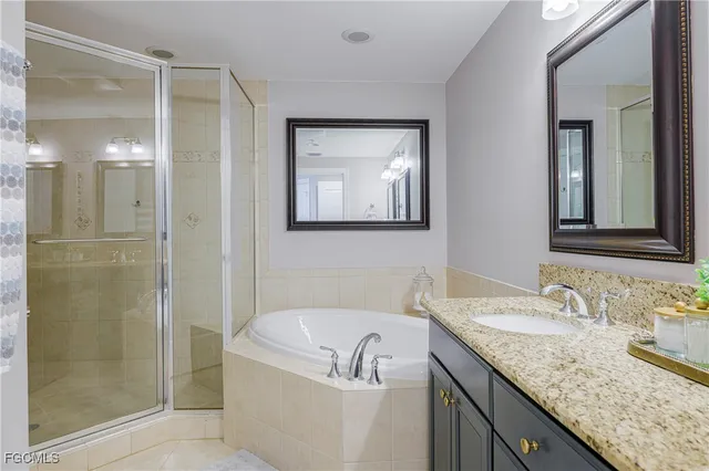 a bathroom with a granite countertop sink a mirror a shower and vanity