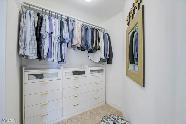 a view of walk in closet with clothes and shoes