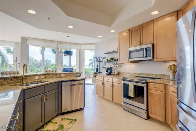 a kitchen with stainless steel appliances granite countertop a stove a sink and a microwave